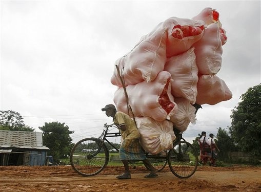 Hindistan’ın Tripura şehrinde plastik toplarla dolu çuvalları taşıyan bir vagon sürücüsü.